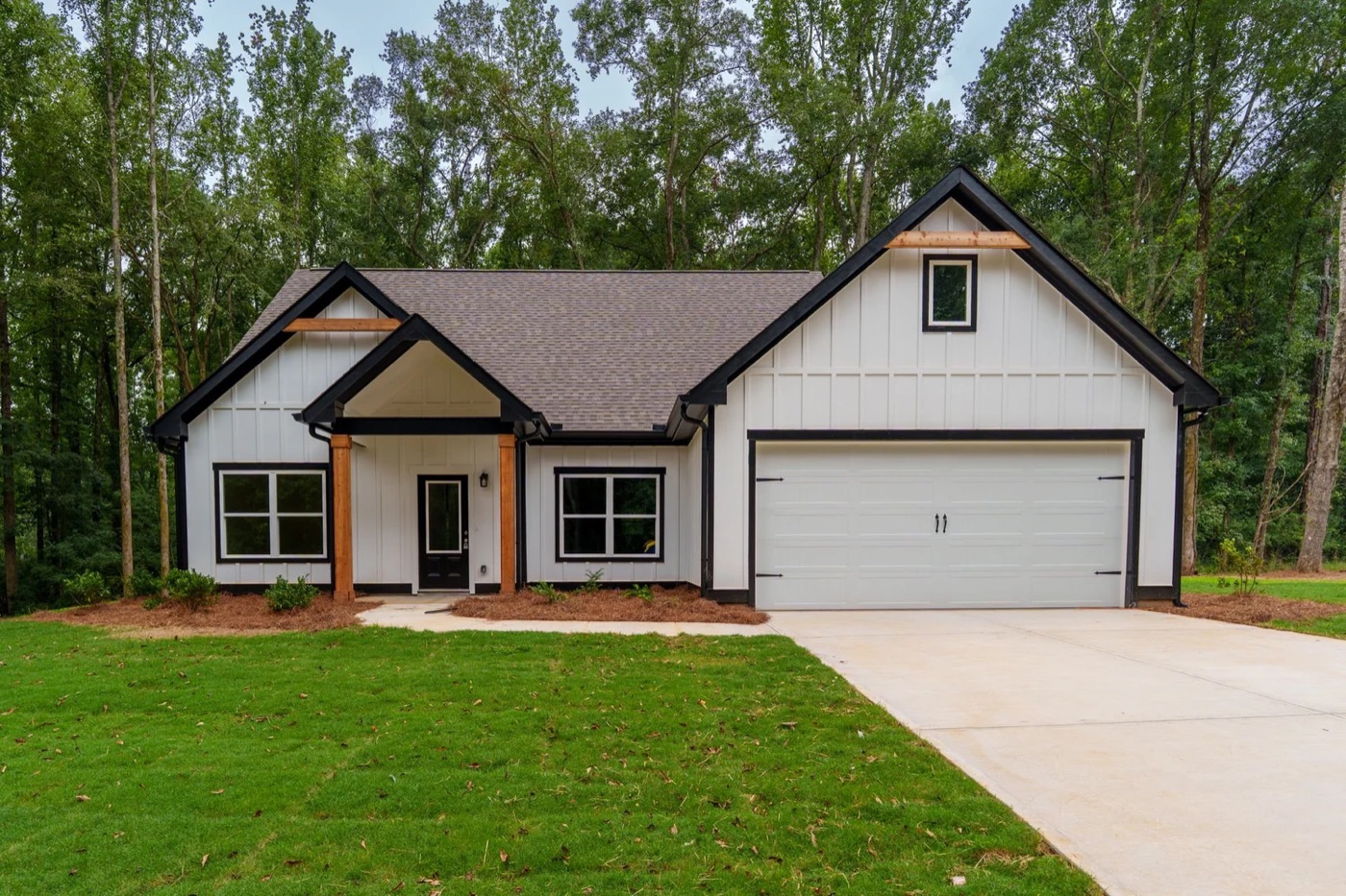 The Keeneland, a white board-and-batten home with a two-car garage