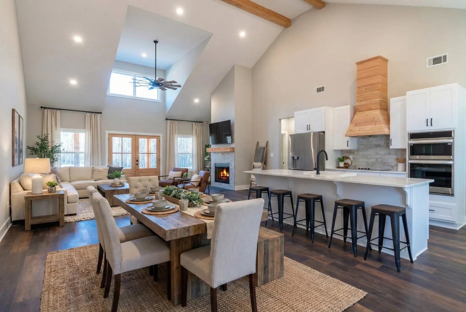 Open great room with a vaulted beamed ceiling, kitchen island and fireplace